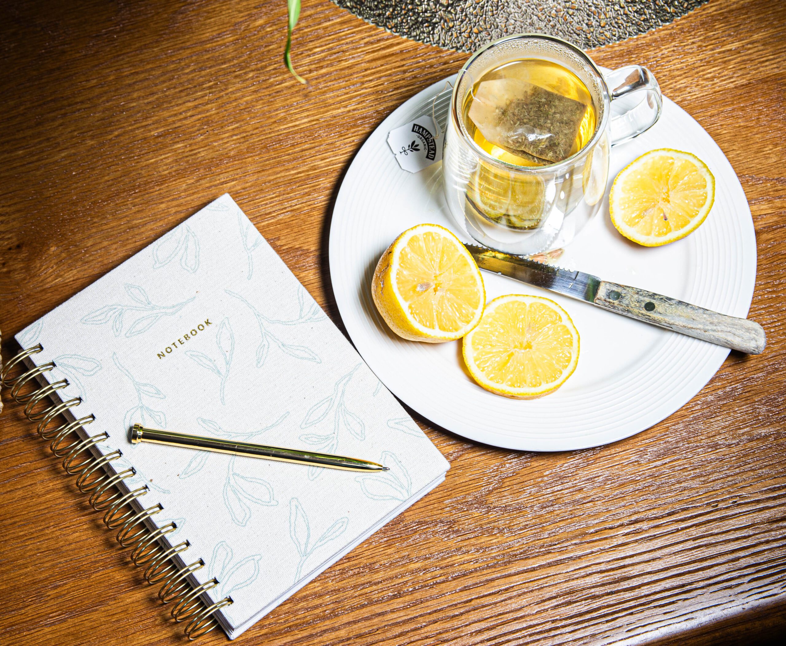 white ceramic mug with coffee beside green book