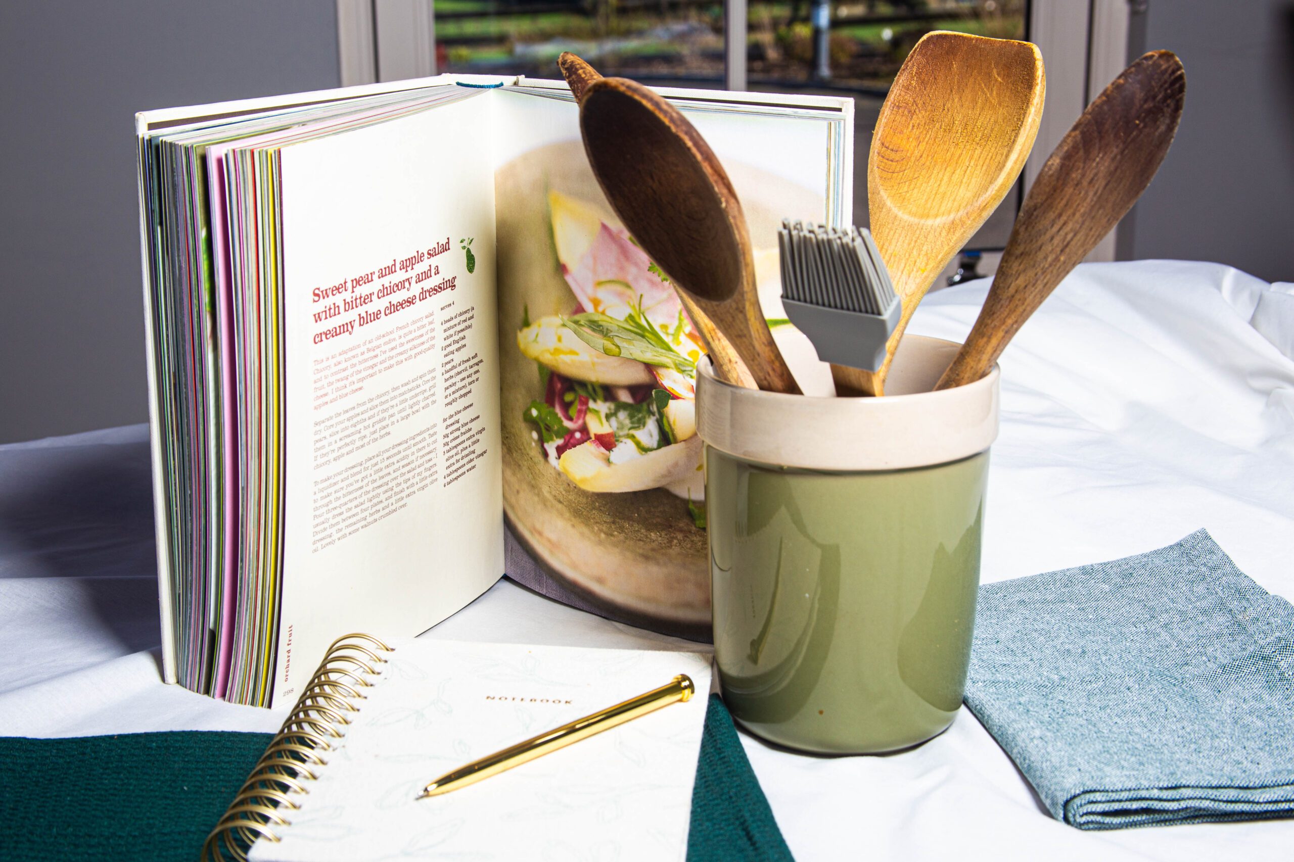 photo of laptop on desk with notebook and pen on top of it